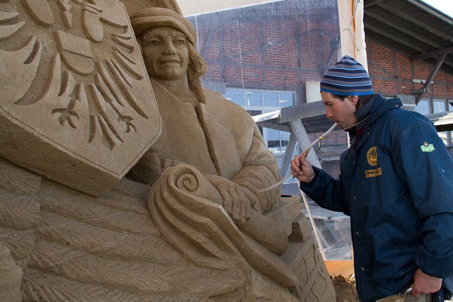 Andrey Molokov mit seiner Sandskulptur „Kaufmann der Hanse, Verbund der Hansestädte“