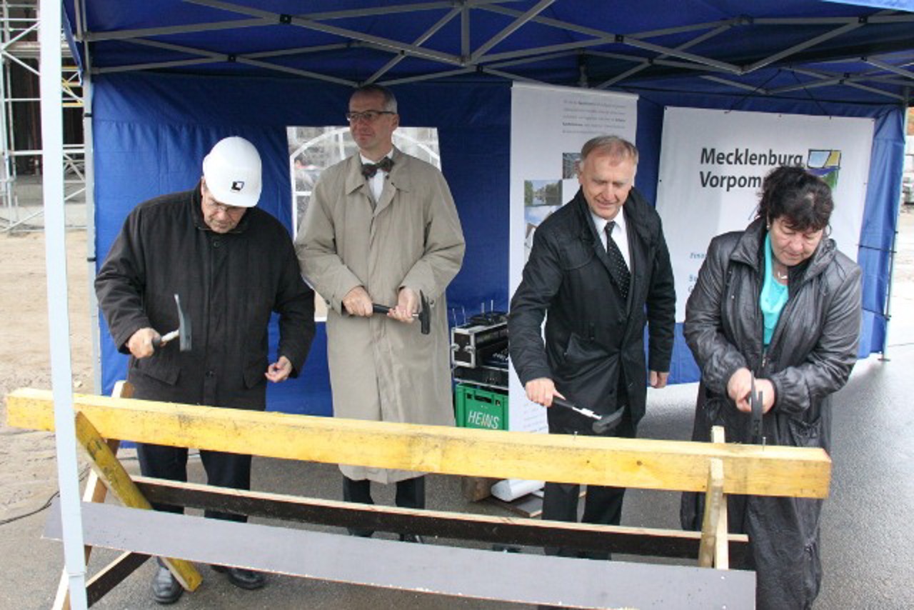 Rektor Wolfgang Schareck, Oliver Kühn (Institut für Physik), Karl-Heinz Meiwes-Broer (Leiter des Departments Leben, Licht & Materie) und Finanzministerin Heike Polzin versenken die letzten Nägel