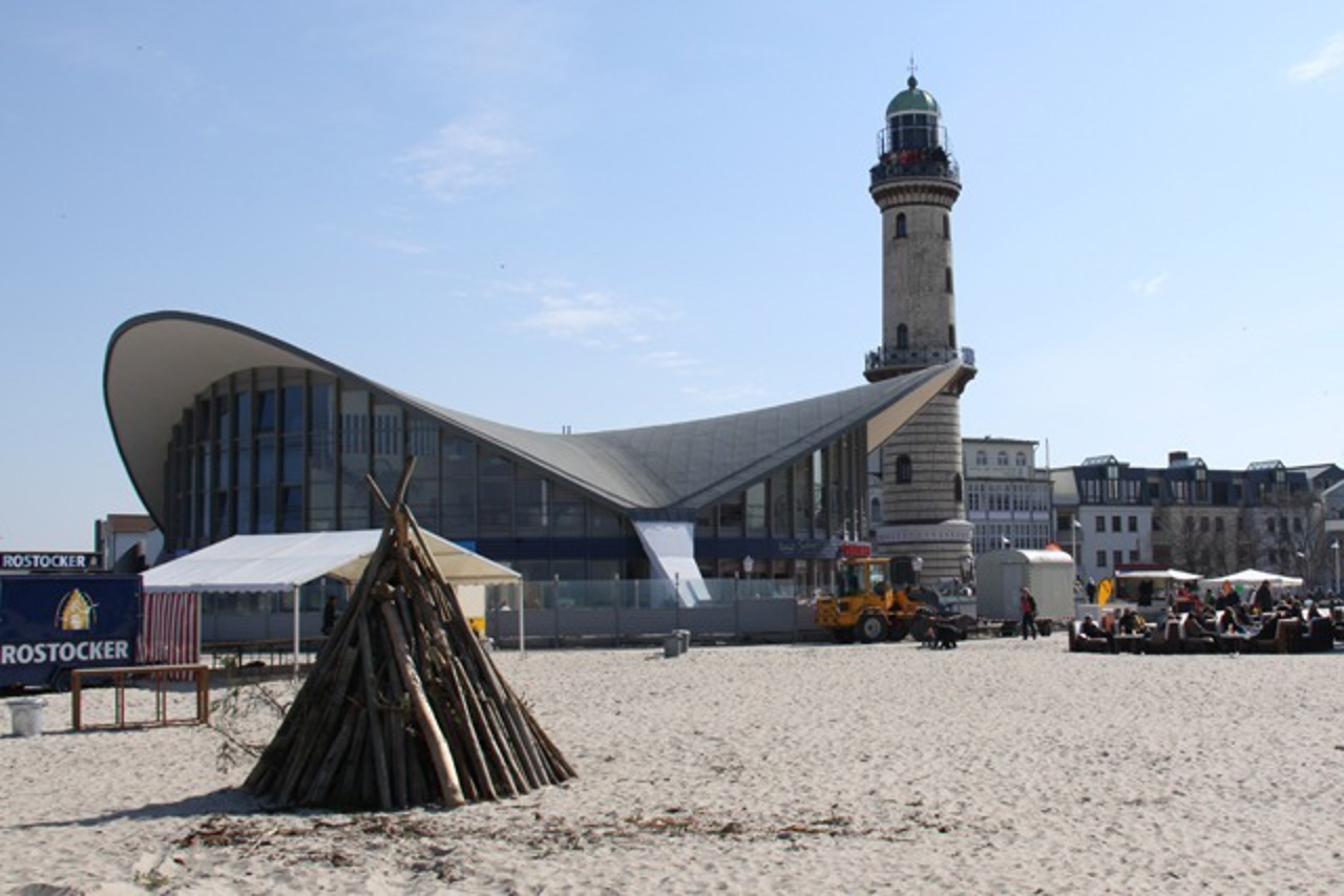 Vorbereitungen fürs Osterfeuer am Strand von Warnemünde vor der Kulisse von Teepott und Leuchtturm