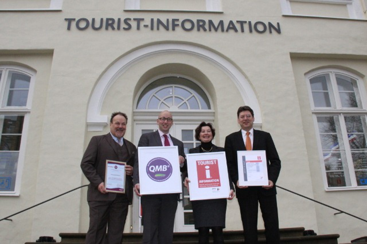 QMB-Siegel und rote i-Marke für die Tourist-Information Rostock - Bernd Fischer, Matthias Fromm, Karina Jens und Reinhard Meyer