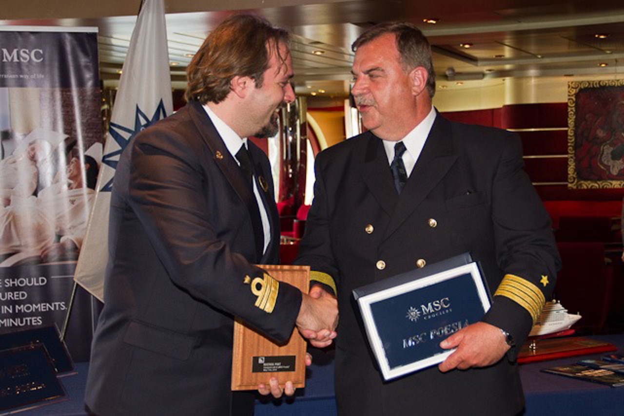 Der italienische Kapitän der Poesia Marco Massa erhält von Hafenkapitän Gisbert Ruhnke eine Plakette anlässlich des Erstanlaufs eines MSC Kreuzfahrtschiffes in Warnemünde.