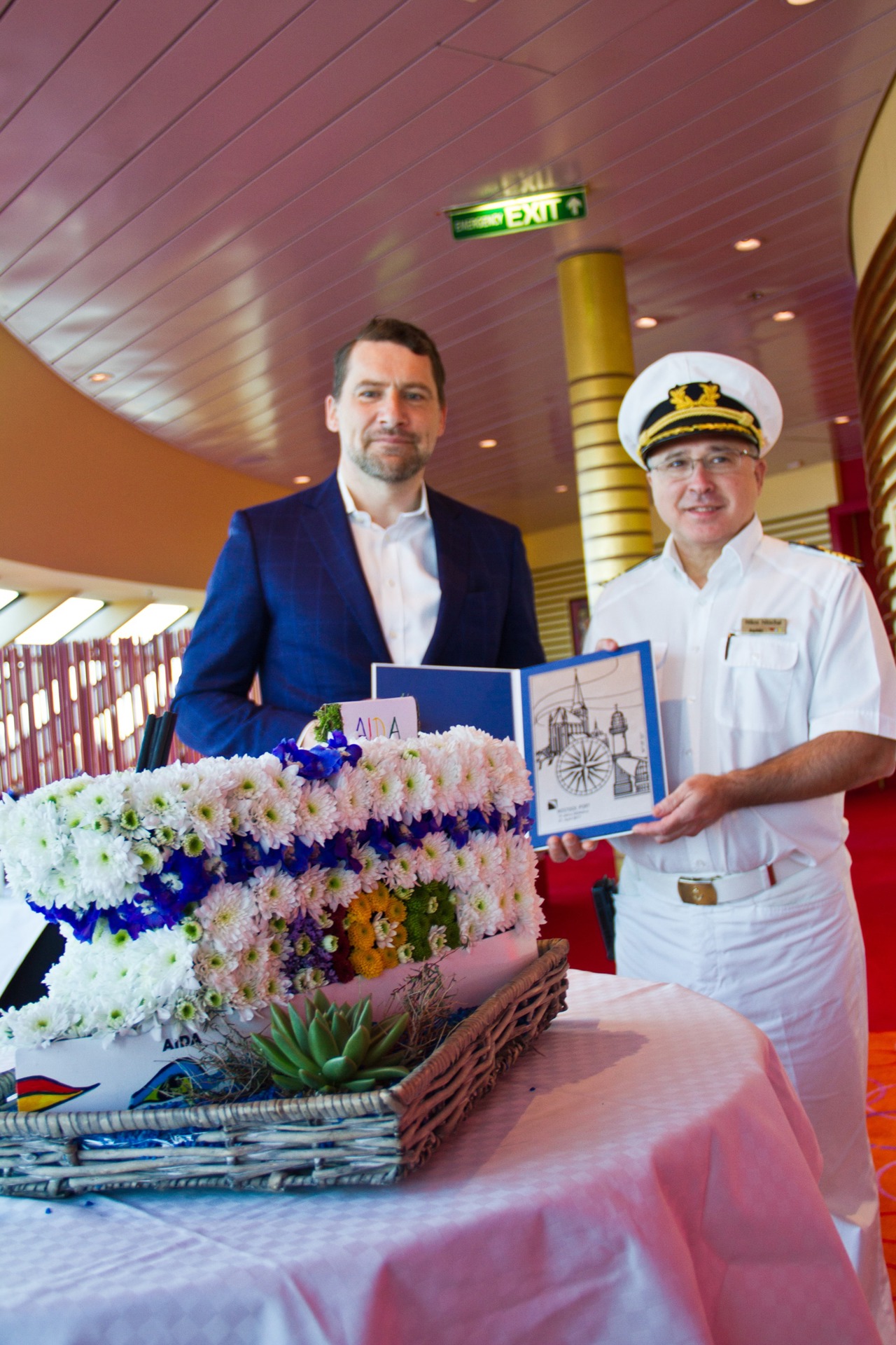 Rostock Port Geschäftsführer Jens A. Scharner überreicht AIDAdiva-Kapitän Nikos Nitschai Geschenke zum Taufjubiläum.