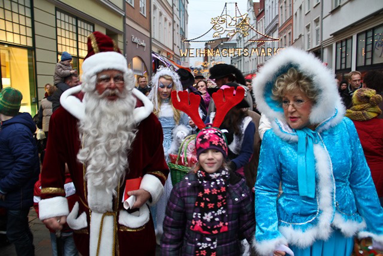 Der Weihnachtsmann und sein Märchengefolge ziehen auf dem Rostocker Weihnachtsmarkt ein.