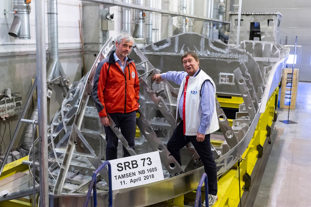 Dr. Helmut Elsner legt unter den Augen von DGzRS-Inspektor Carl Göner (li.) eine Zehn-Euro-Gedenkmünze von 2008 zum 50. Geburtstag des Segelschulschiffs „Gorch Fock“ in eine Sektion des Seenotrettungsbootes SRB 73 ein. Elsners 2016 verstorbener Vater, Gerhard Elsner, hatte die Seenotretter in seinem Nachlass großzügig bedacht und damit maßgeblich zur Finanzierung des Neubaus beigetragen. (Foto: DGzRS – Die Seenotretter)