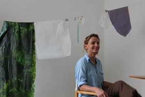 Annette Czerny vor Papierbahnen im Gastatelier Rostock