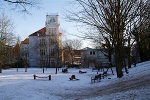 Spielplatz im Probsteigarten. Der Schnee bedeckt die kahle Rasenfläche, die der Historische Weihnachtsmarkt im Dezember 2011 hier hinterließ