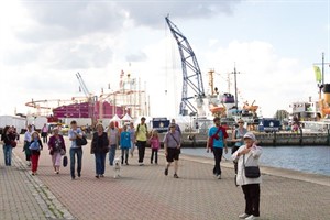 Im Christinenhafen herrscht reges Treiben. Passanten beobachten, wie die Fahrgeschäfte und Bühnen aufgebaut werden.