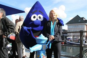 Gesine Strohmeyer und Tröpfli, das Maskottchen von Eurawasser vor dem neuen Trinkwasserbrunnen "Lütt Pütt"