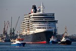 Die Queen Elizabeth wird von mehreren Schleppern und einem Feuerlöschboot bei ihrem Erstanlauf in Warnemünde begleitet