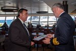 Hafenkapitän Gisbert Ruhnke übergibt dem Kapitän der Nieuw Statendam Sybe de Boer die traditionelle Plakette zum Erstanlauf in Rostock-Warnemünde